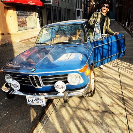Mea Planert's husband Mark Normand posing with his car in West Village